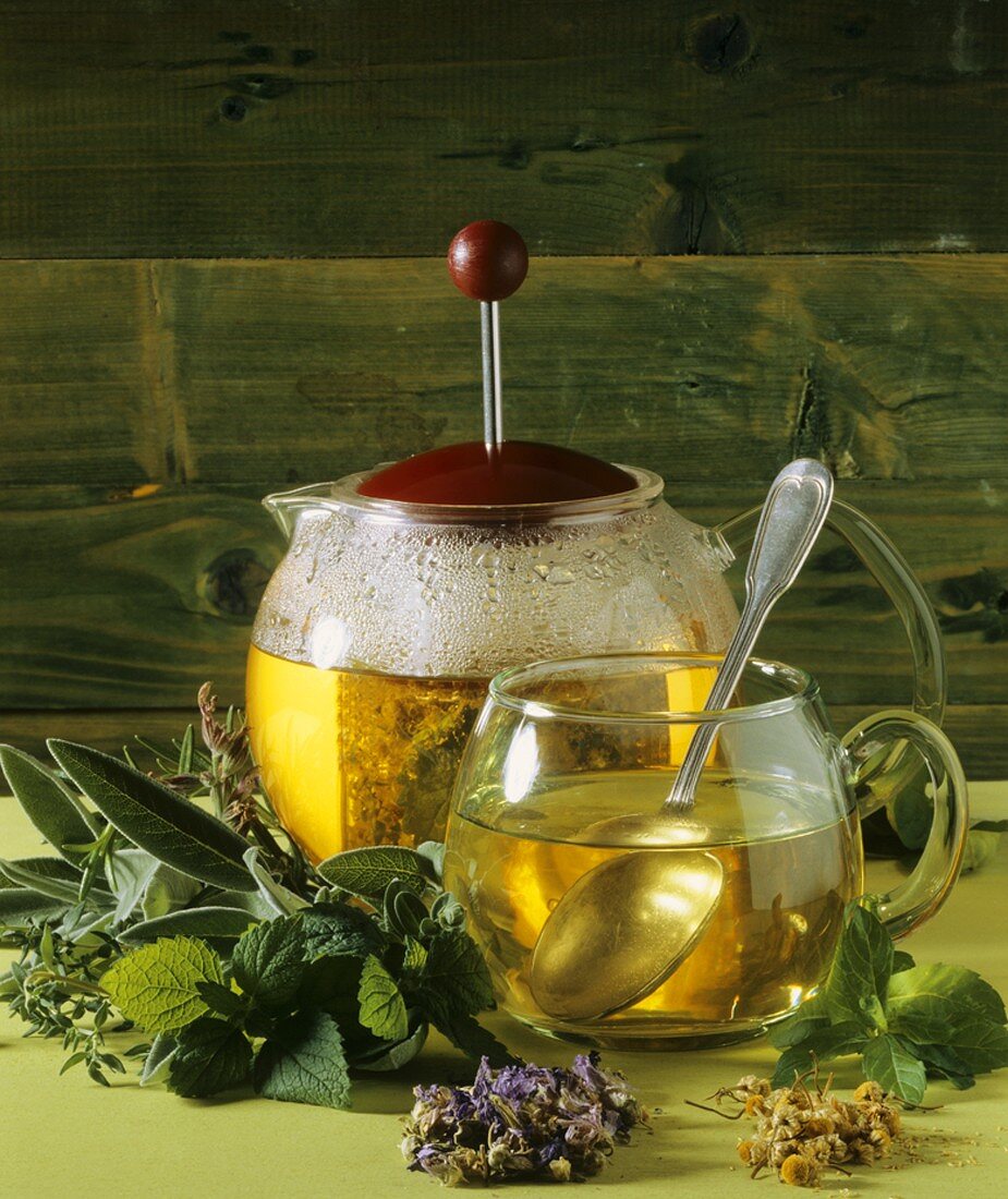 Herb tea in teapot and glass cup