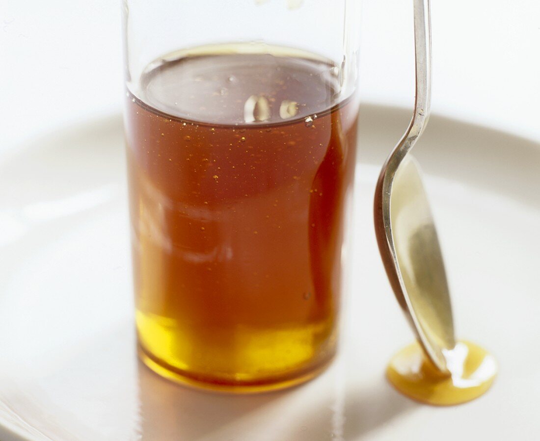 Glass of honey and spoon