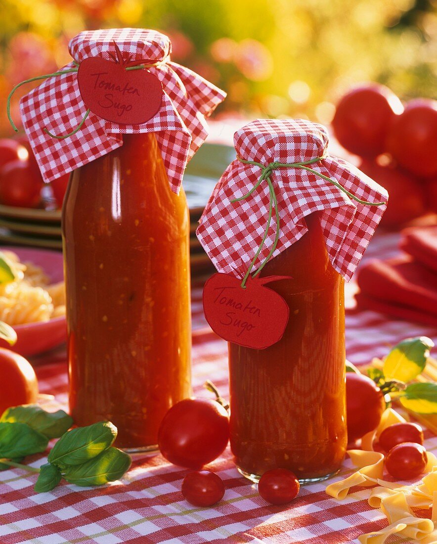 Tomato sugo in bottles, tomatoes, basil and pasta