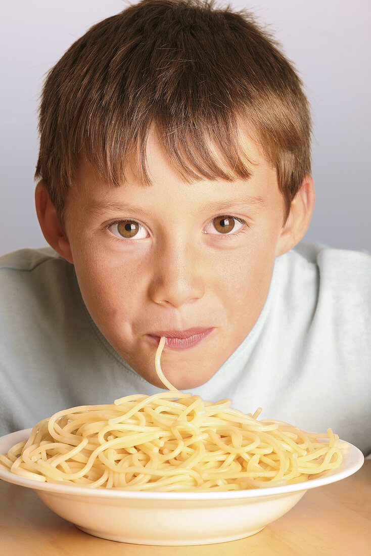 Boy eating spaghetti