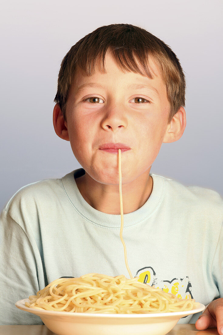 Boy eating spaghetti