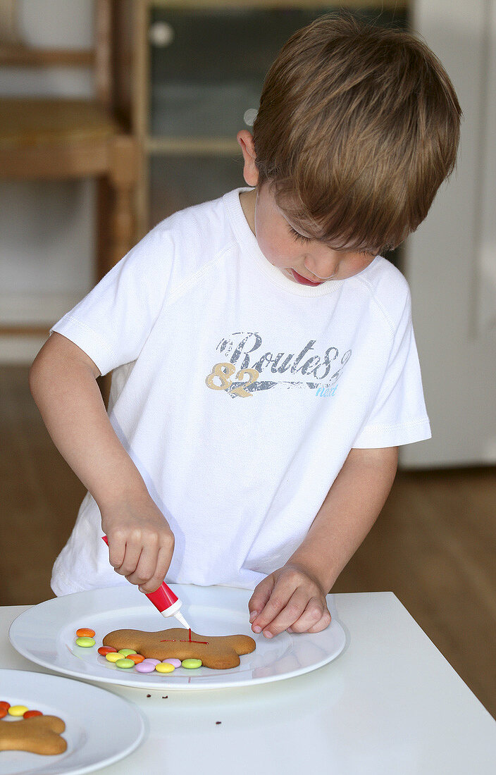 Boy decorating a gingerbread man