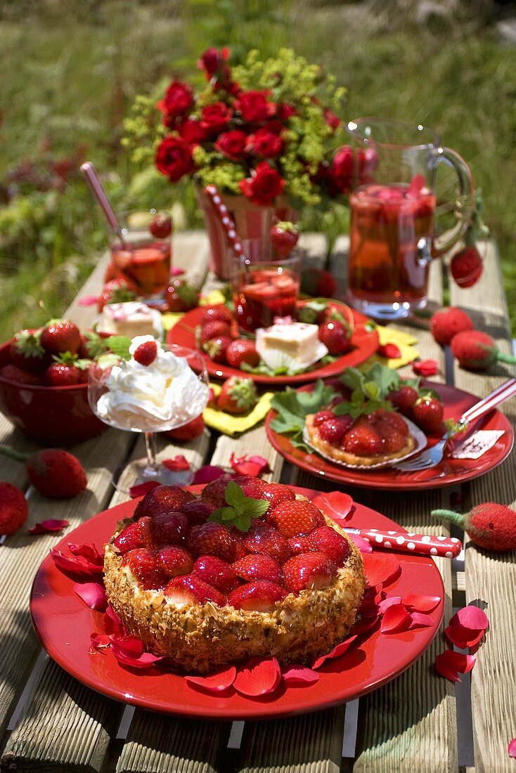 Strawberry torte with rose petals on a garden table