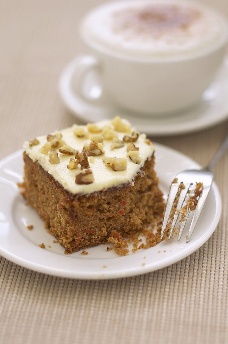 A piece of carrot cake with cappuccino