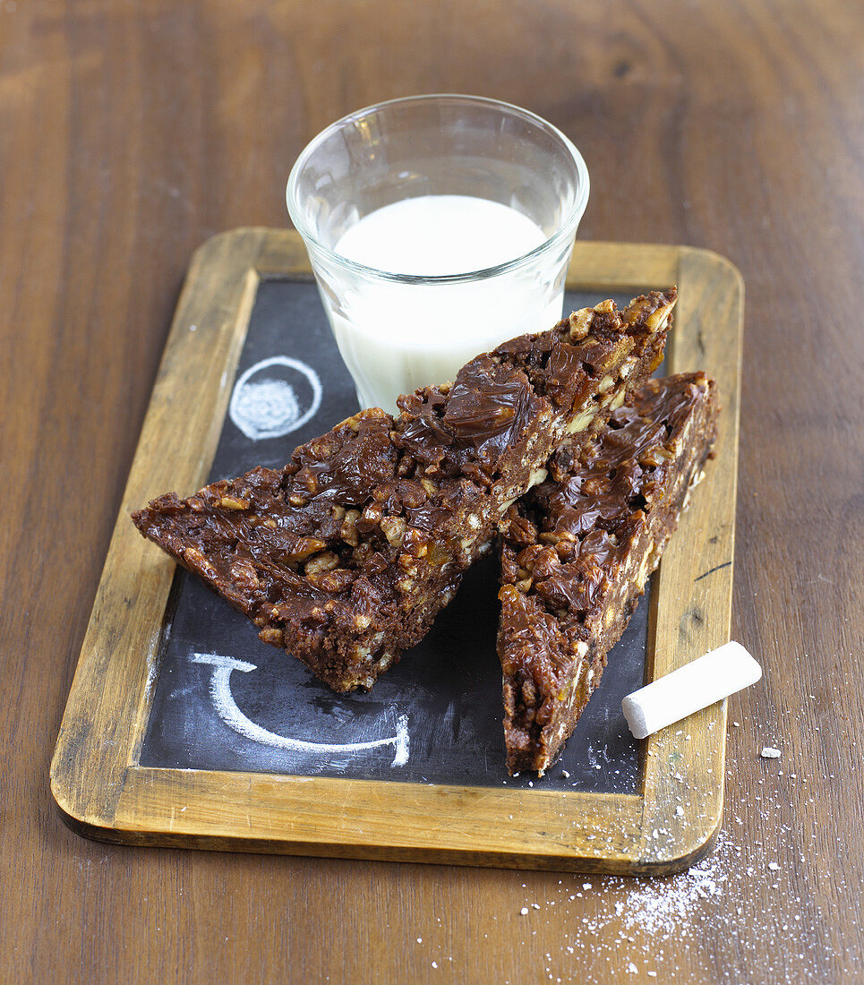 Pecan chocolate cake and a glass of milk on a slate