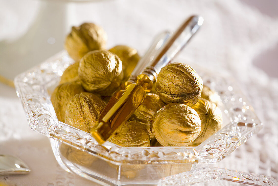 Christmas decoration: golden walnuts in glass bowl
