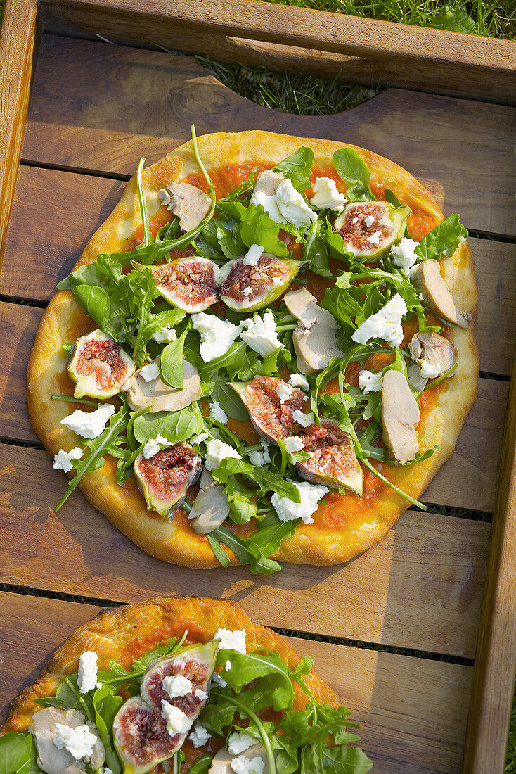 Pizza topped with foie gras, rocket and figs