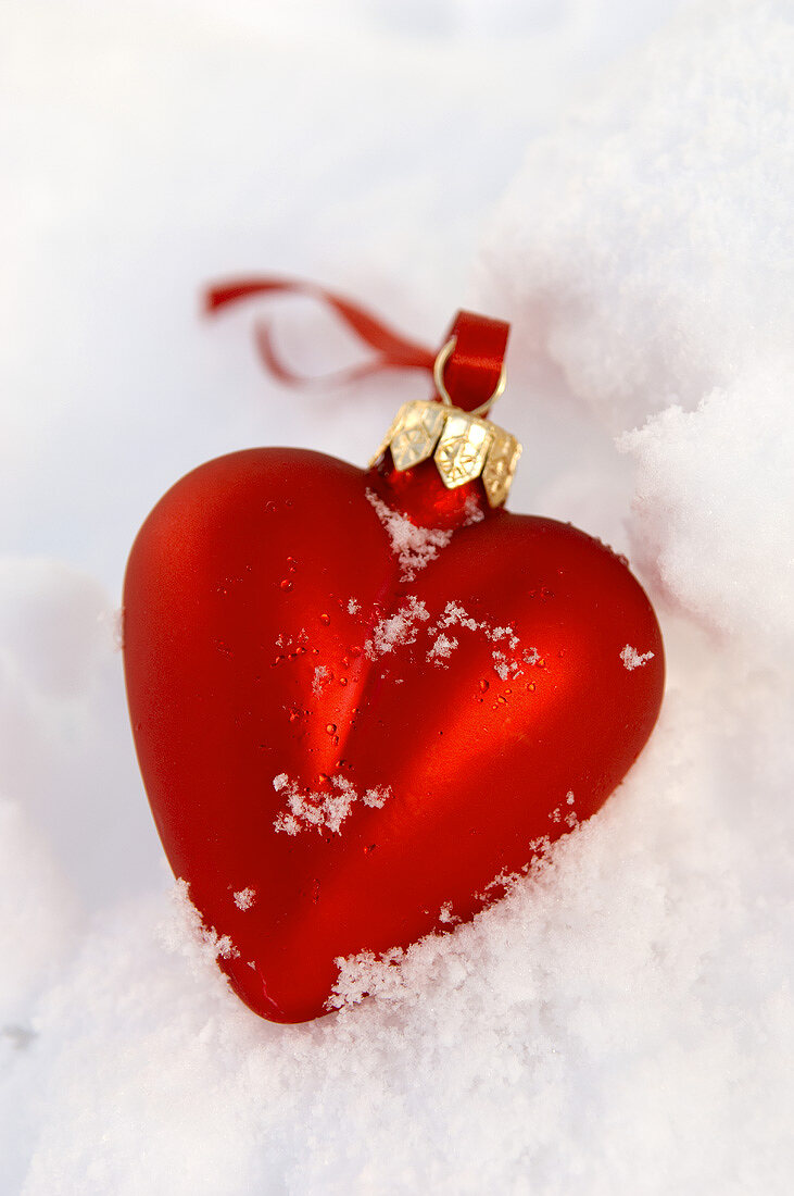 Heart-shaped Christmas tree ornament in snow