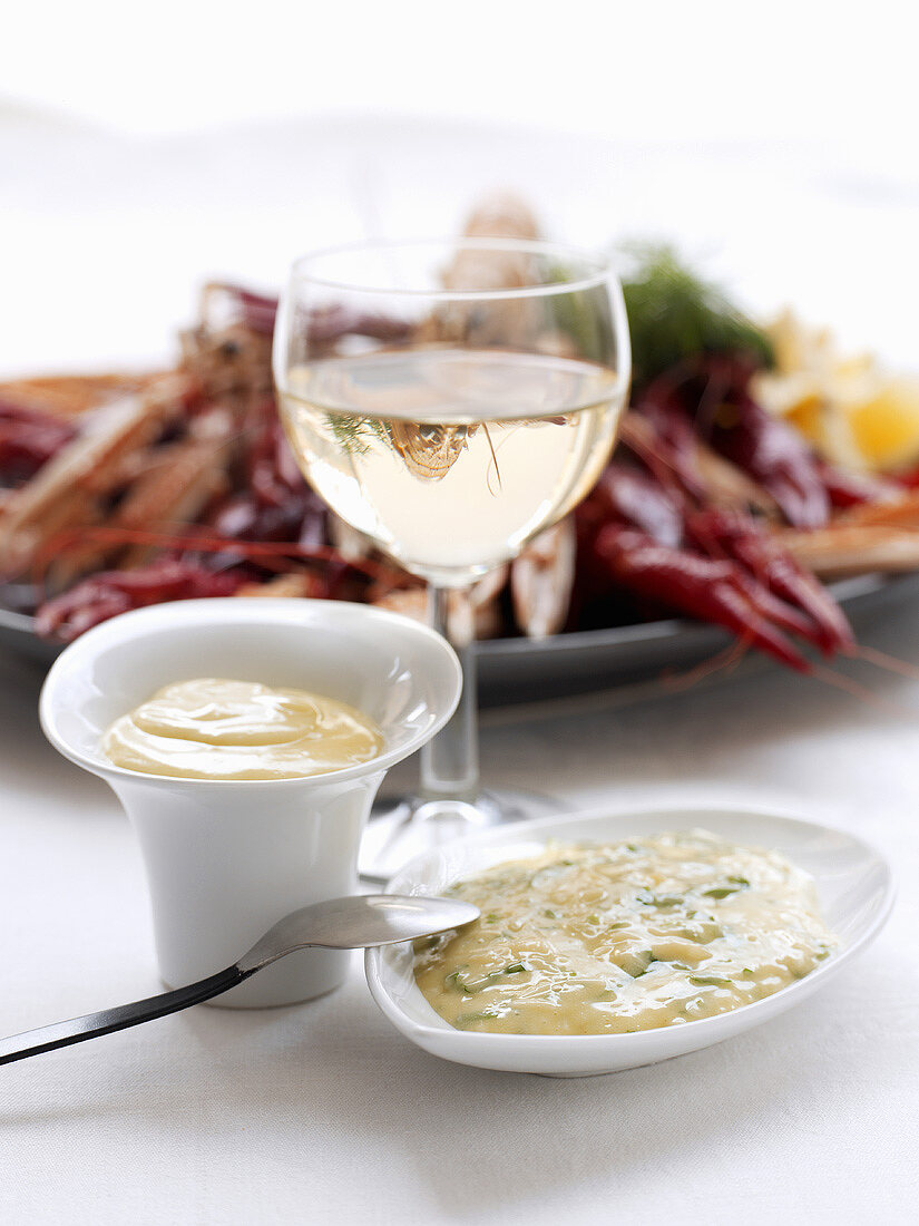 Aioli, a glass of white wine and seafood platter