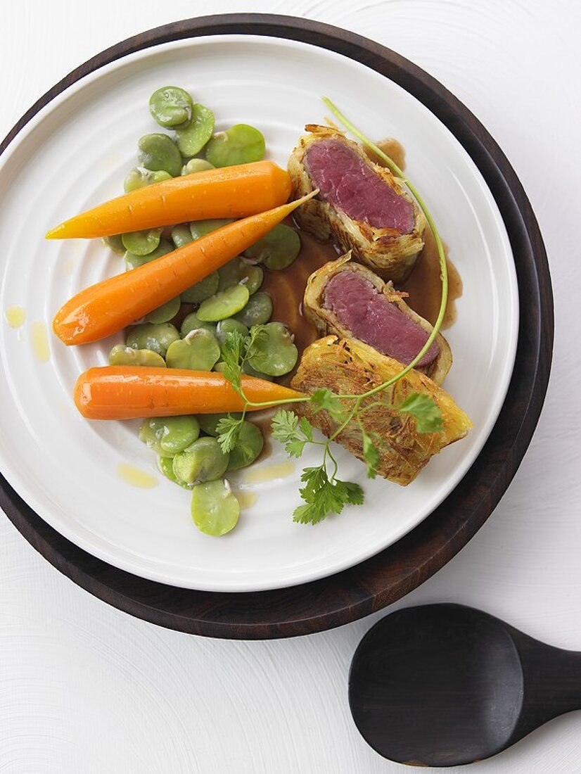 Loin of lamb in artichoke bottoms with beans and carrots