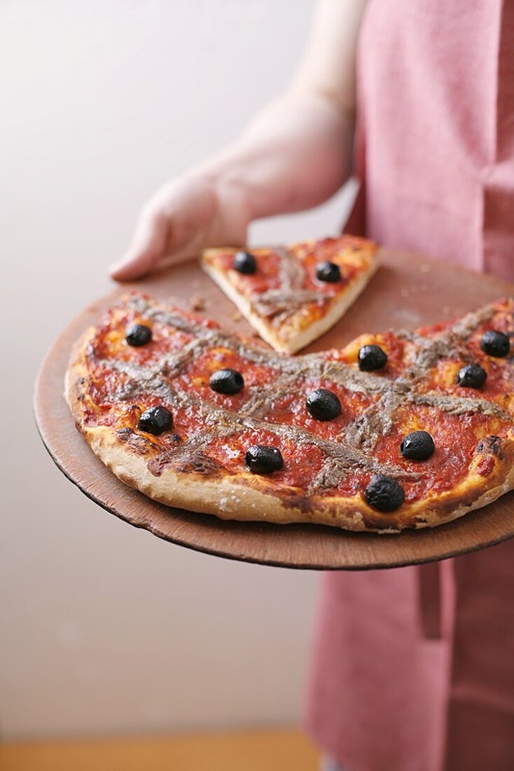 Pizza mit schwarzen Oliven und Sardellenfilets