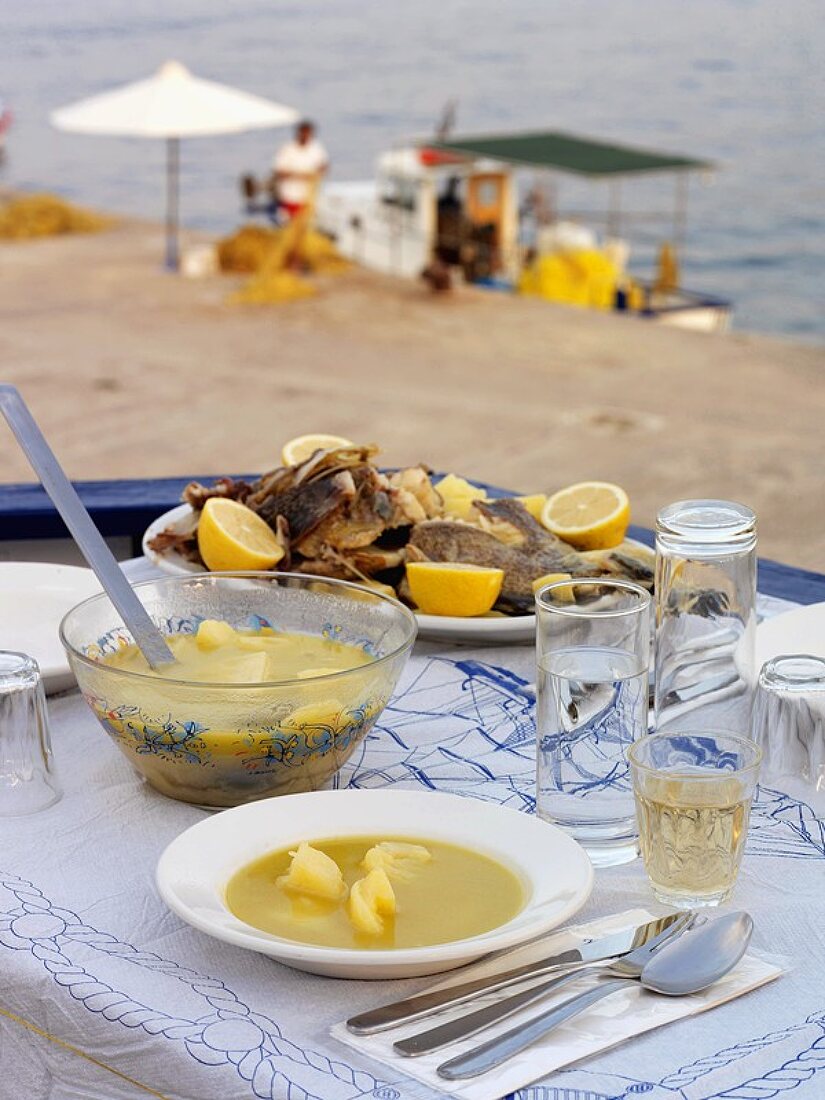 Griechische Fischsuppe, im Hintergrund das Meer