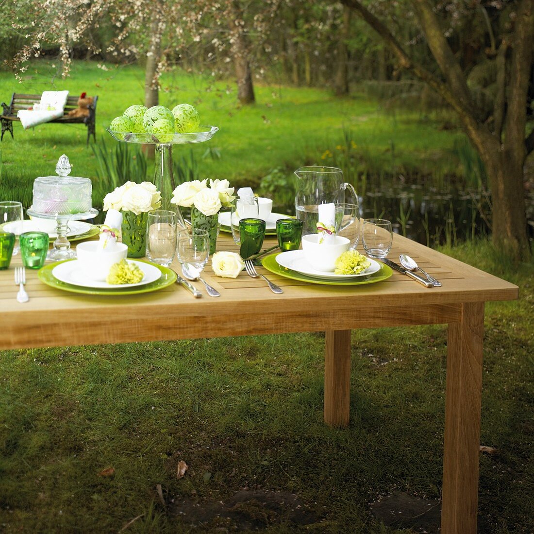 Laid table decorated with white roses in garden