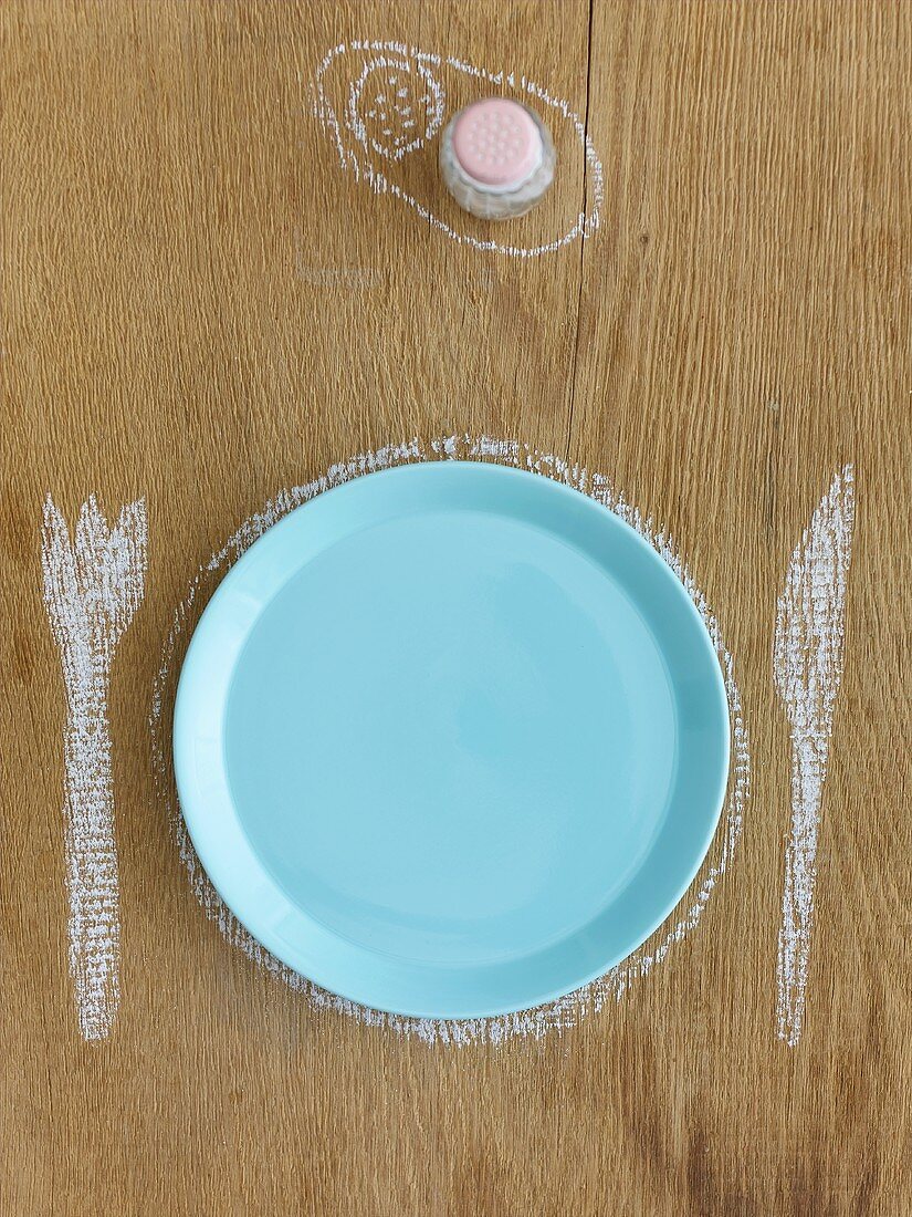 Plate, knife & fork drawn in chalk, salt shaker in background