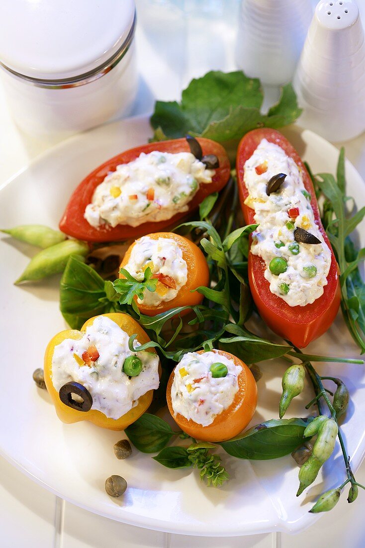 Tomatoes stuffed with soft cheese on salad leaves