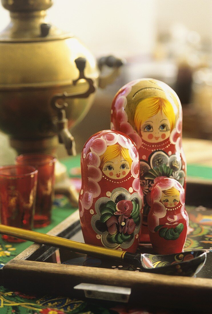 Matrjoschka-Puppen, im Hintergrund Samowar und Gläser