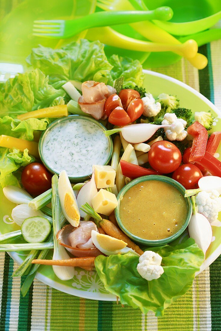 Platter of raw vegetables with two dips