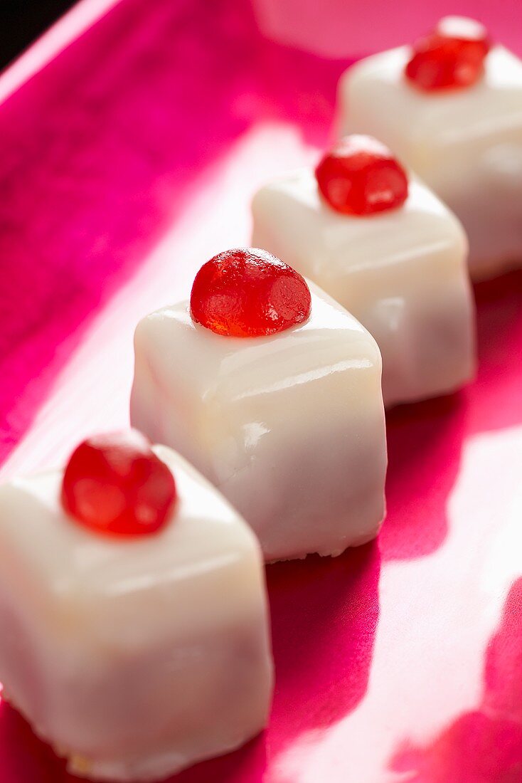 Punschkrapfen (small iced cakes) with cocktail cherries