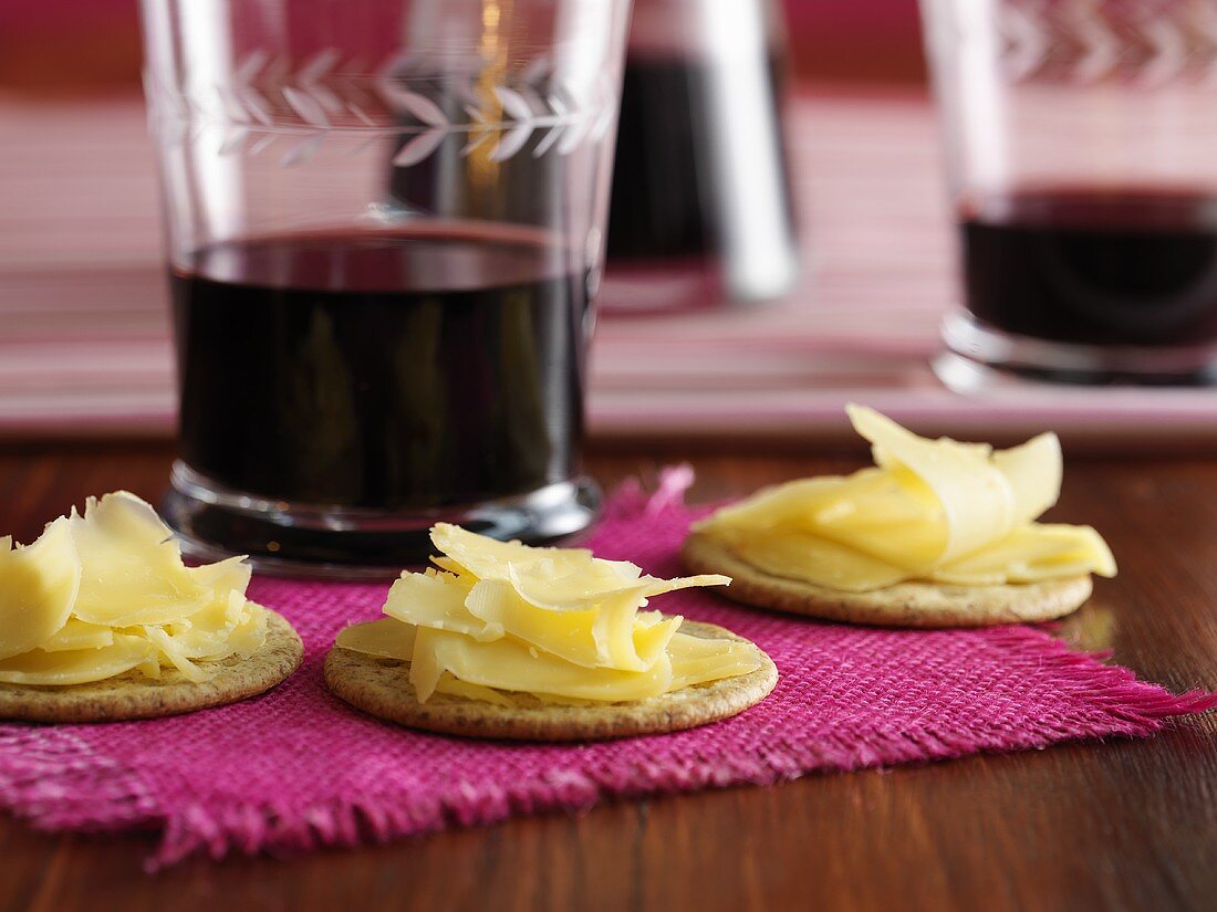 Cheese on crackers and glasses of red wine