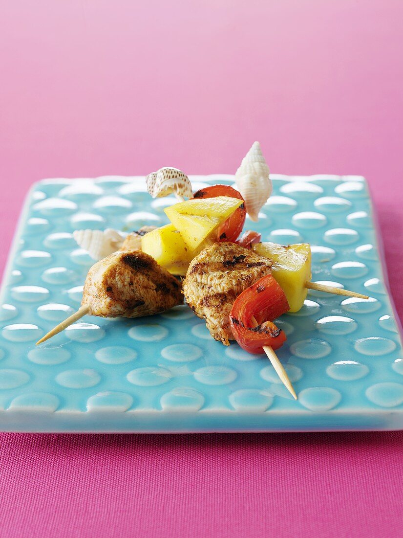 Chicken and pineapple skewers decorated with shells