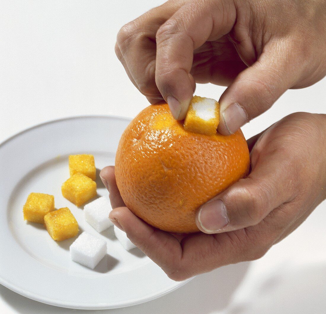 Rubbing orange peel with sugar cubes