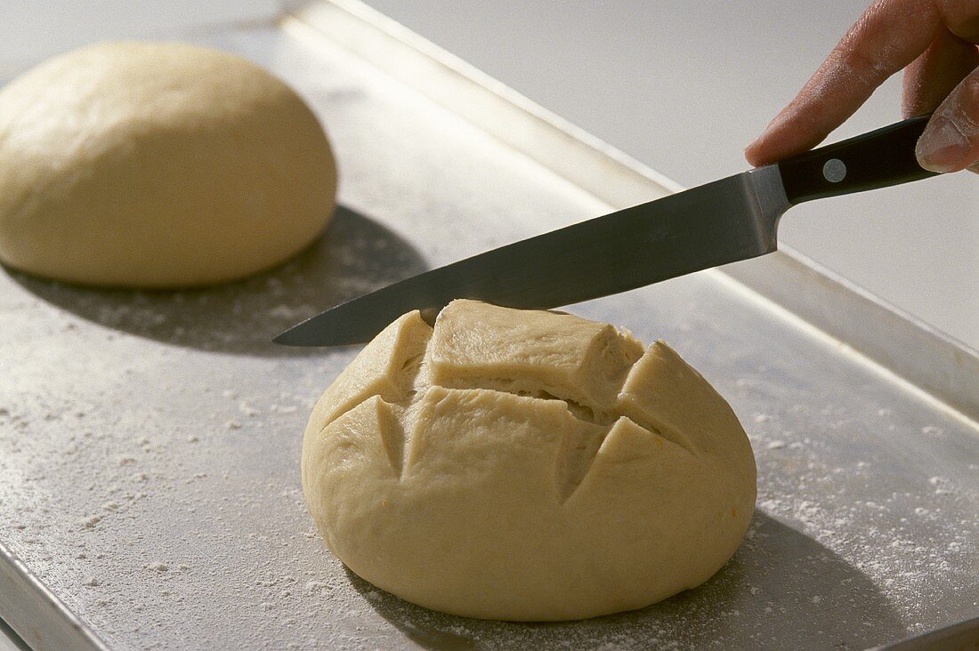 Slashing unbaked bread (Pompe de Noel, sweet French Xmas bread)