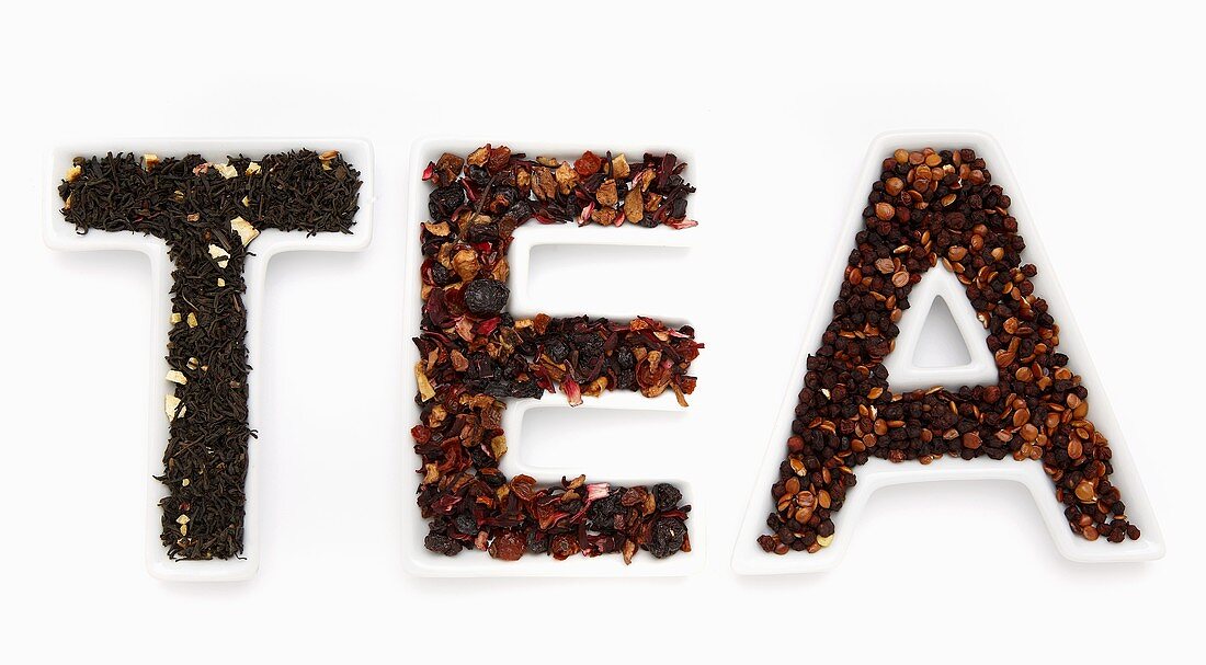 Getrocknete Teeblätter in Schälchen mit Schriftzug TEA