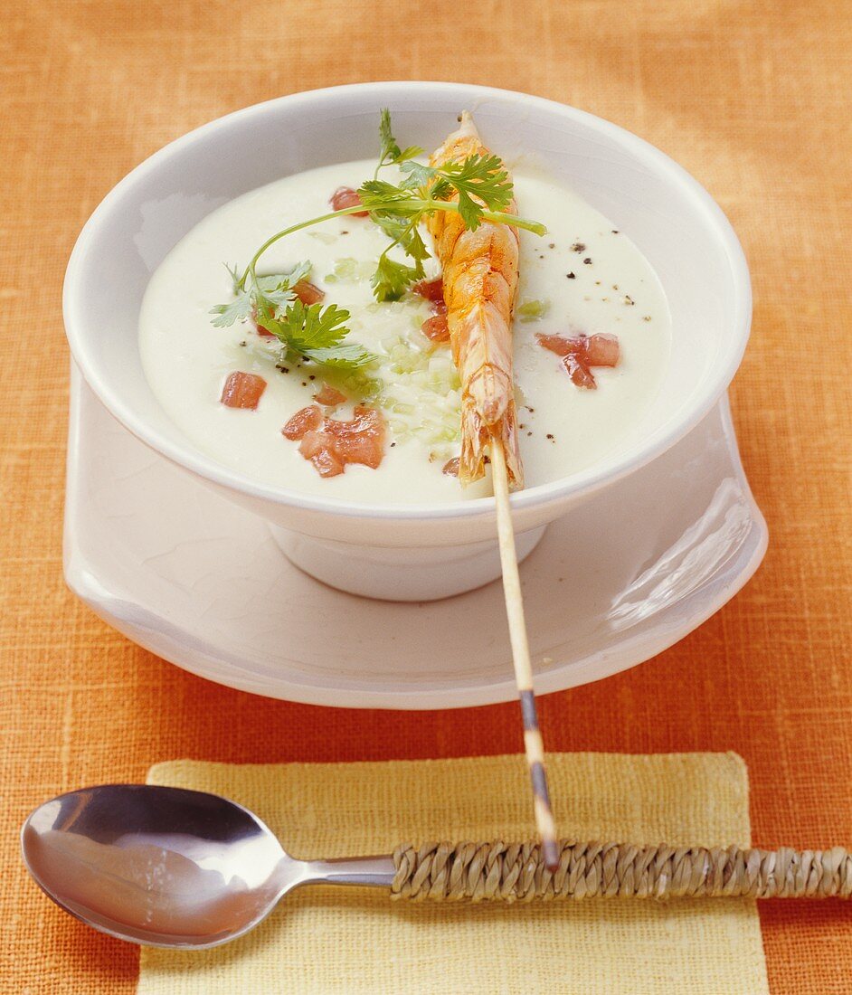 Cold avocado and coconut soup with skewered prawn