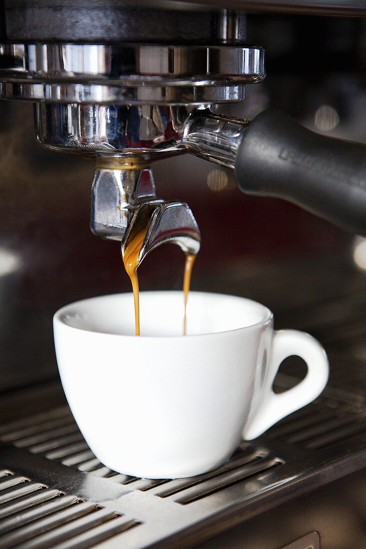 Espresso läuft in eine Tasse