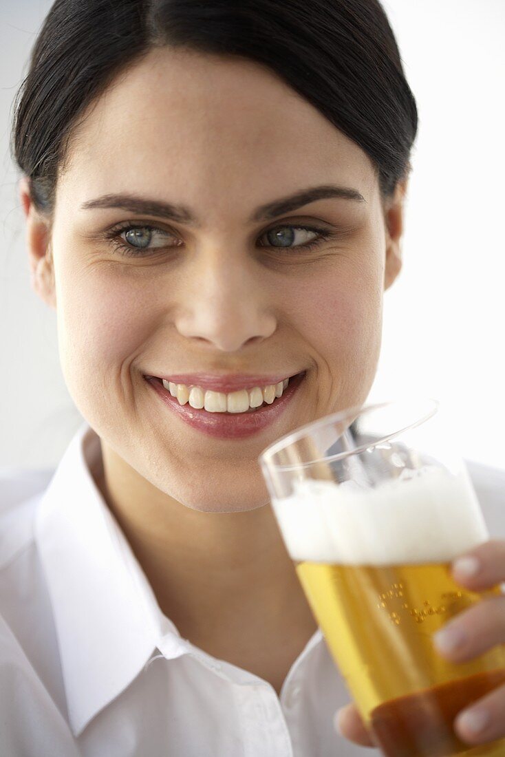 Young woman drinking a glass of beer