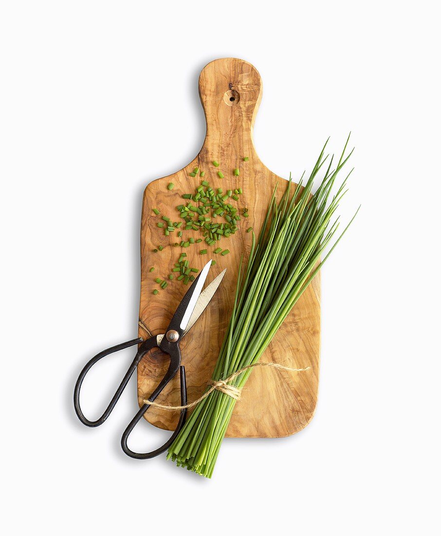 Chives and scissors on chopping board