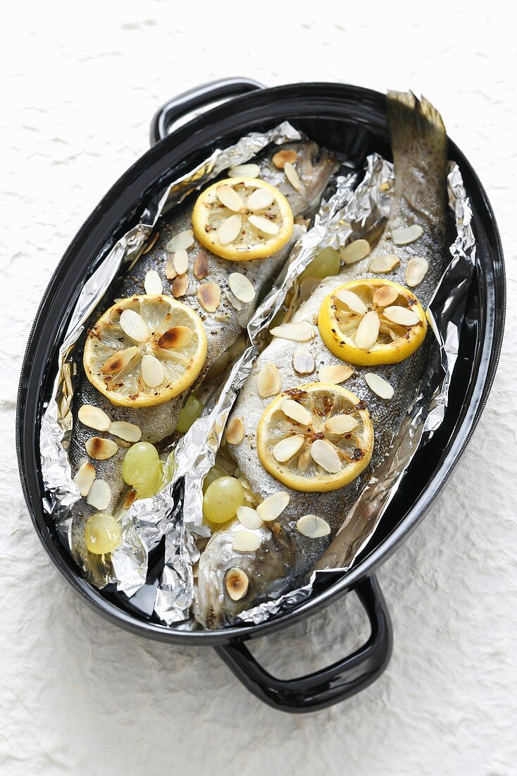 Trout with almonds, grapes and lemon in aluminium foil