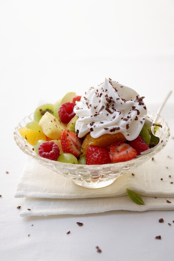 Fruit salad with cream & grated chocolate in glass dish