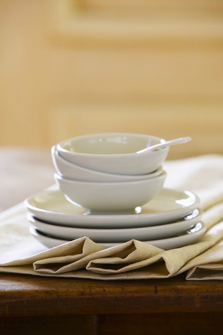 Three white bowls and plates, stacked