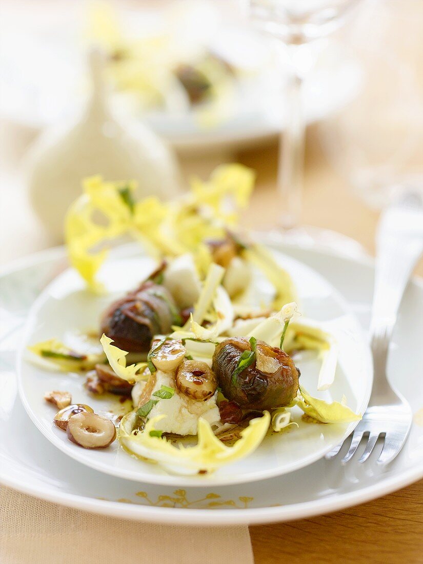 Dandelion salad with bacon-wrapped prunes and hazelnuts