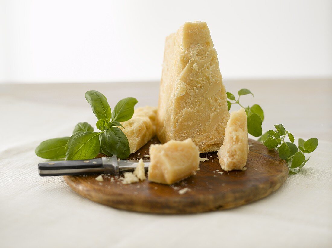 Parmesan mit Basilikum auf Holzbrett