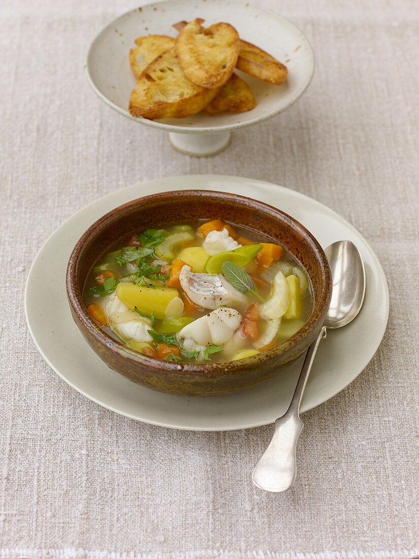 Fischsuppe mit Gemüse, serviert mit Röstbrot