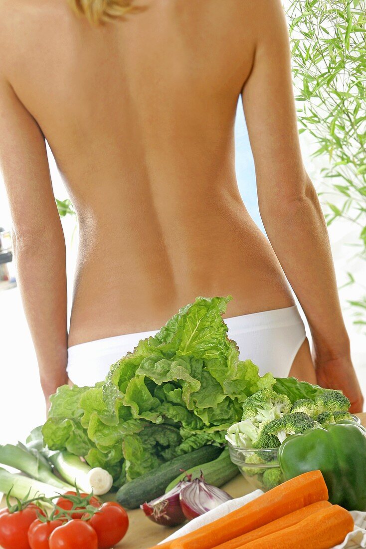 Gemüse und Obst vor nacktem Rücken