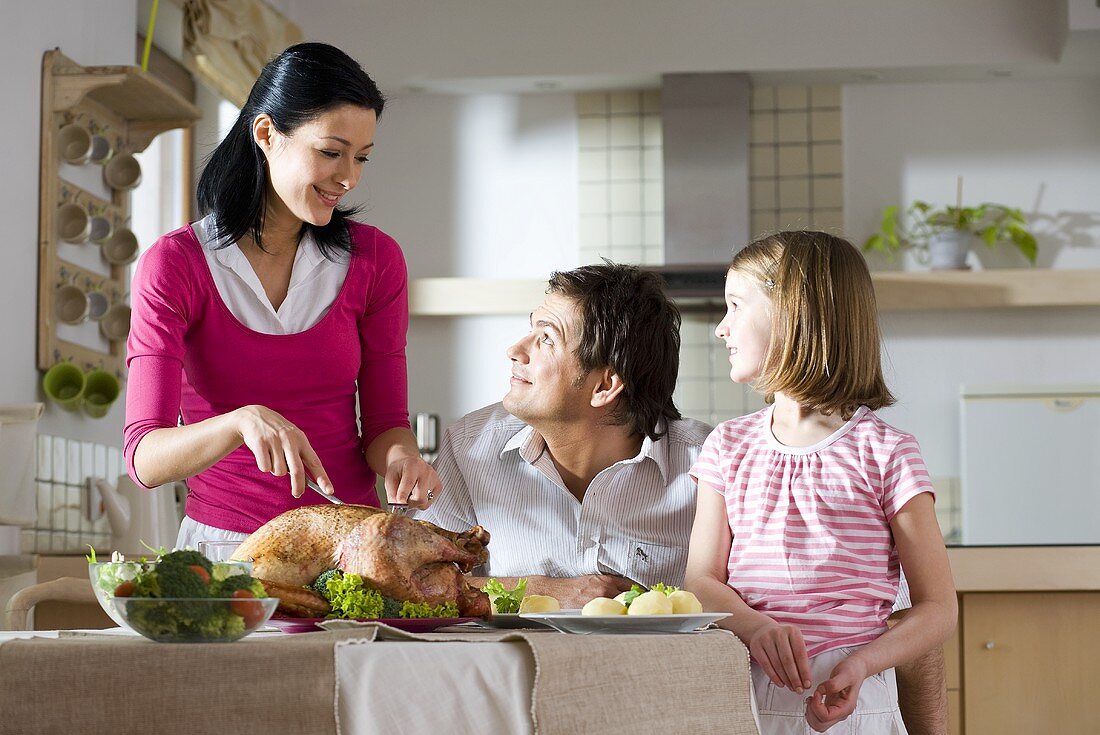 Woman carving roast turkey for the family