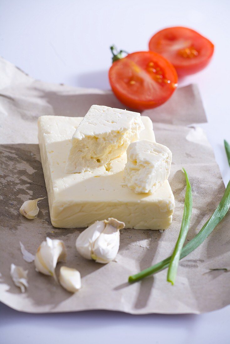 Feta (Schafskäse), Knoblauch und Tomate auf Papier