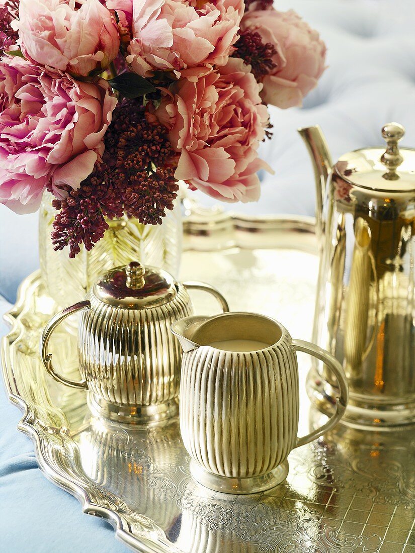 Silver teaset and vase of flowers