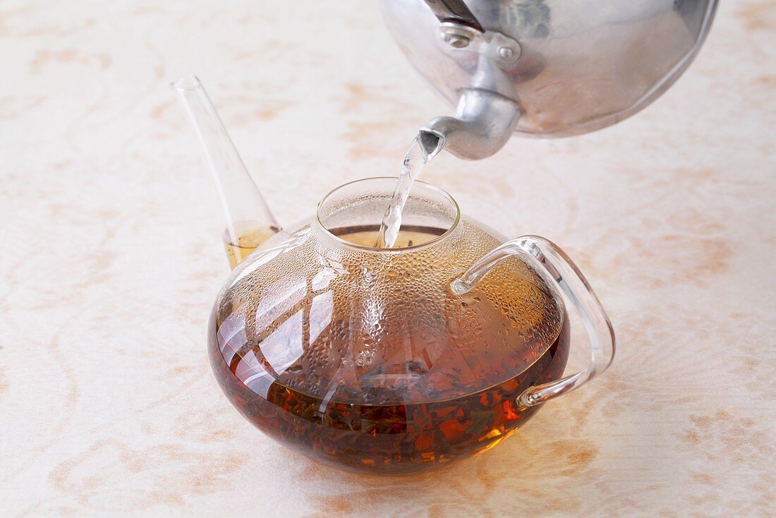 Pouring hot water over tea leaves