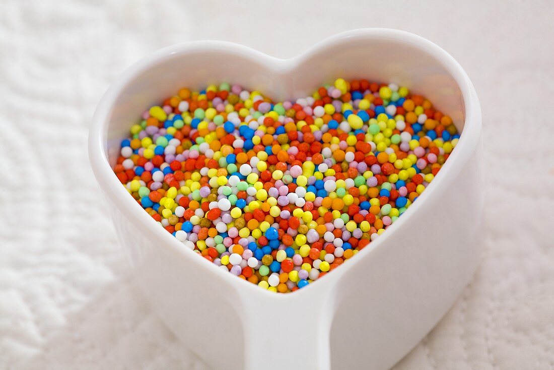 Hundreds and thousands in heart-shaped dish