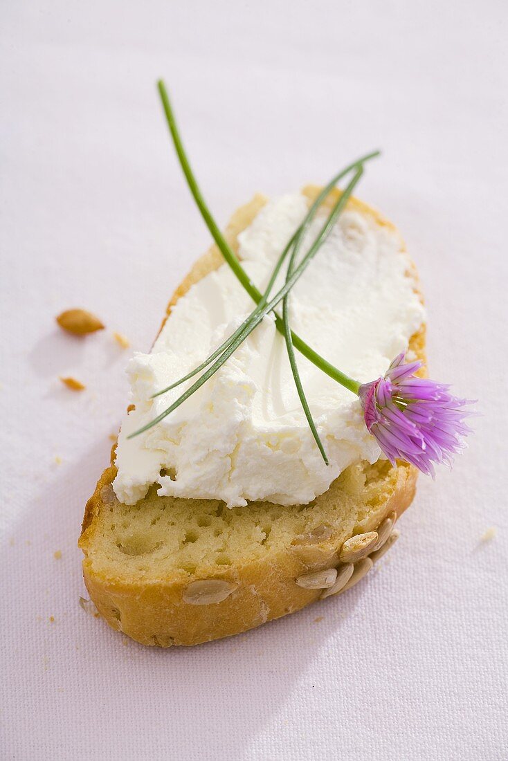 A slice of sunflower bread with quark and chives