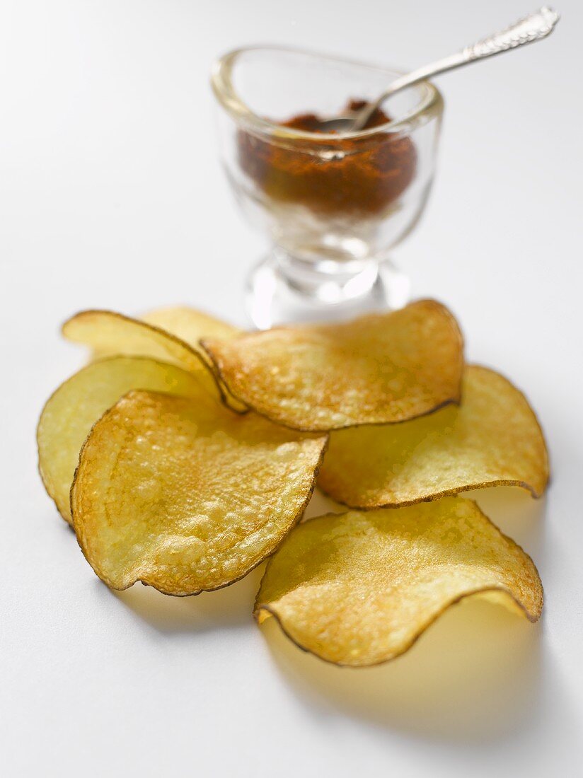 Crisps in front of glass of paprika