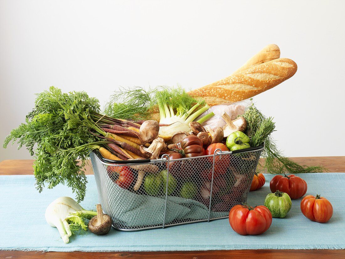 Organic vegetables and baguettes in wire basket