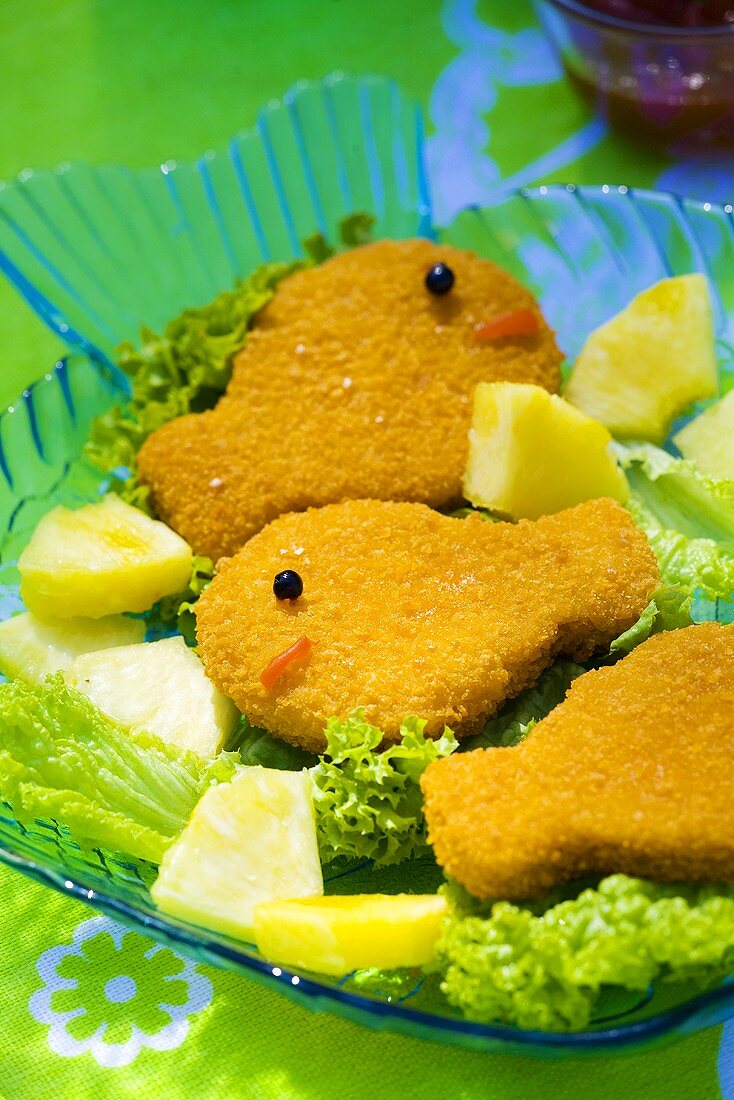 Breaded fish-shaped fish fillets with pineapple