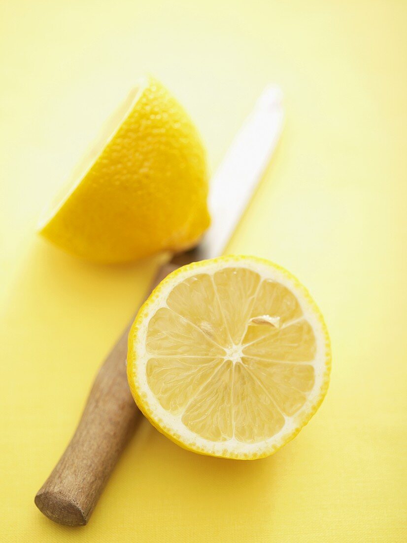 A halved lemon with knife