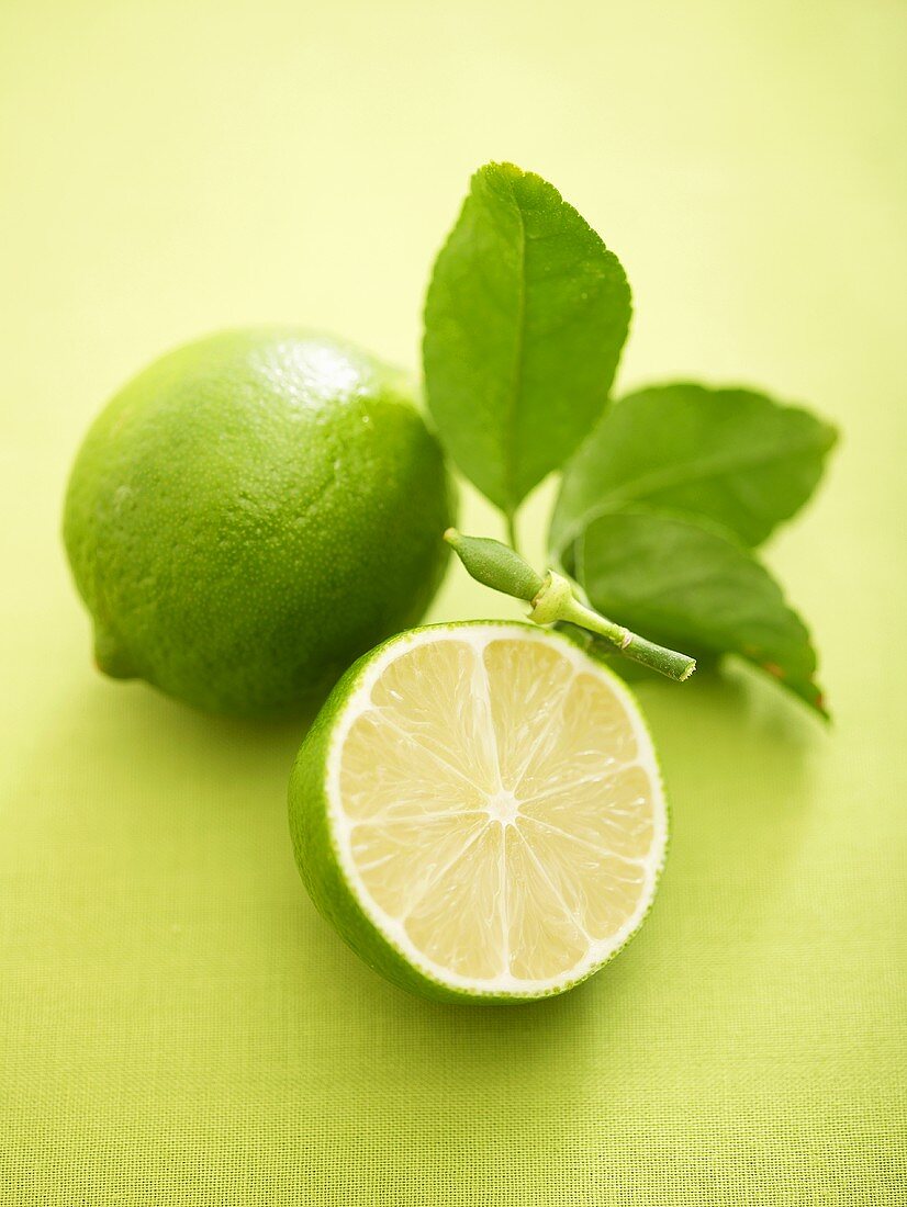Whole lime and half a lime with leaves