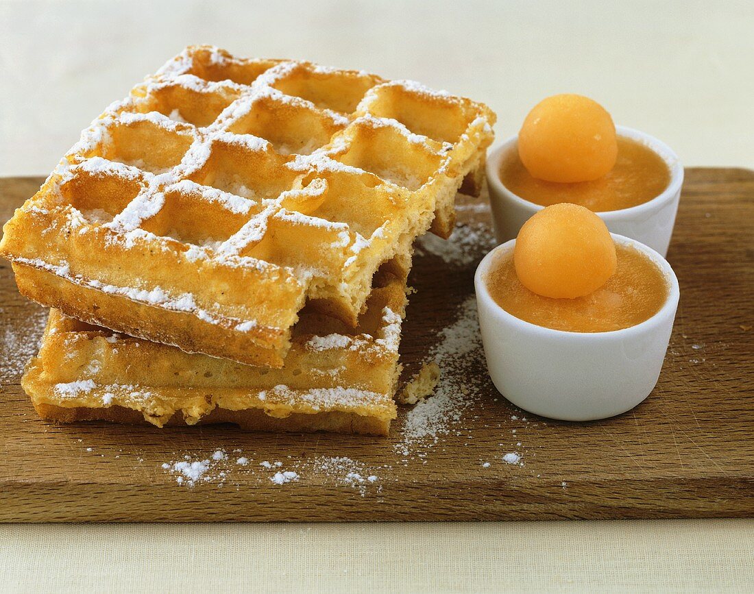 Waffles with icing sugar and frozen melon soup
